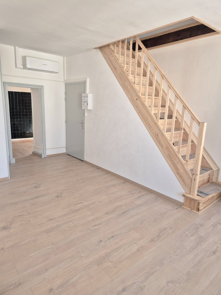 Pièce de vie claire avec escalier en bois
